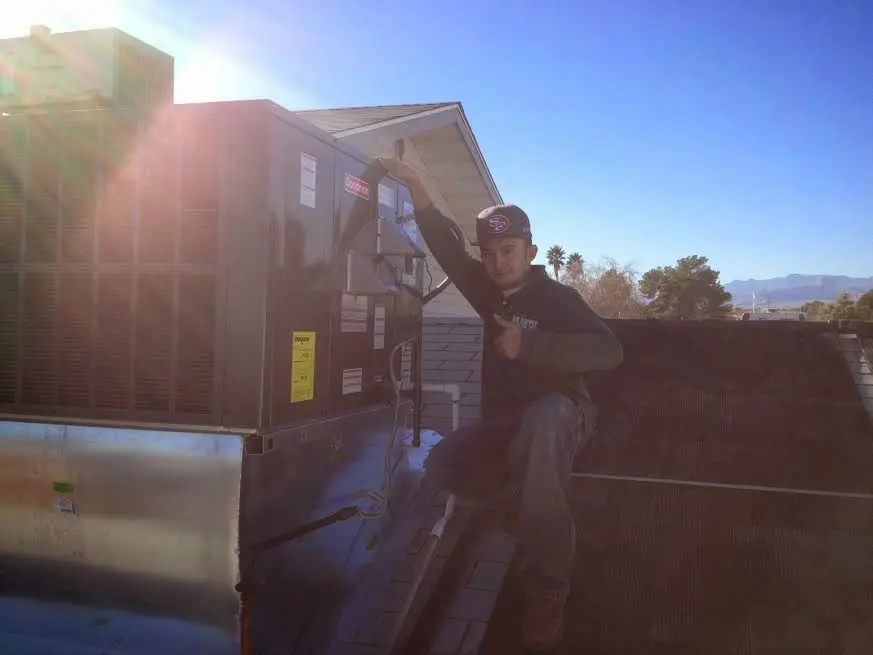HVAC technician performing AC Tune-Up on a rooftop unit in Butte-Silver Bow